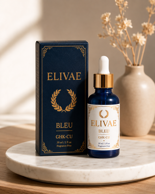 Elivae Bleu bottle with its navy gold-foil box on a marble tray