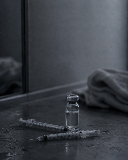 Hypodermic needles arranged on a dark surface